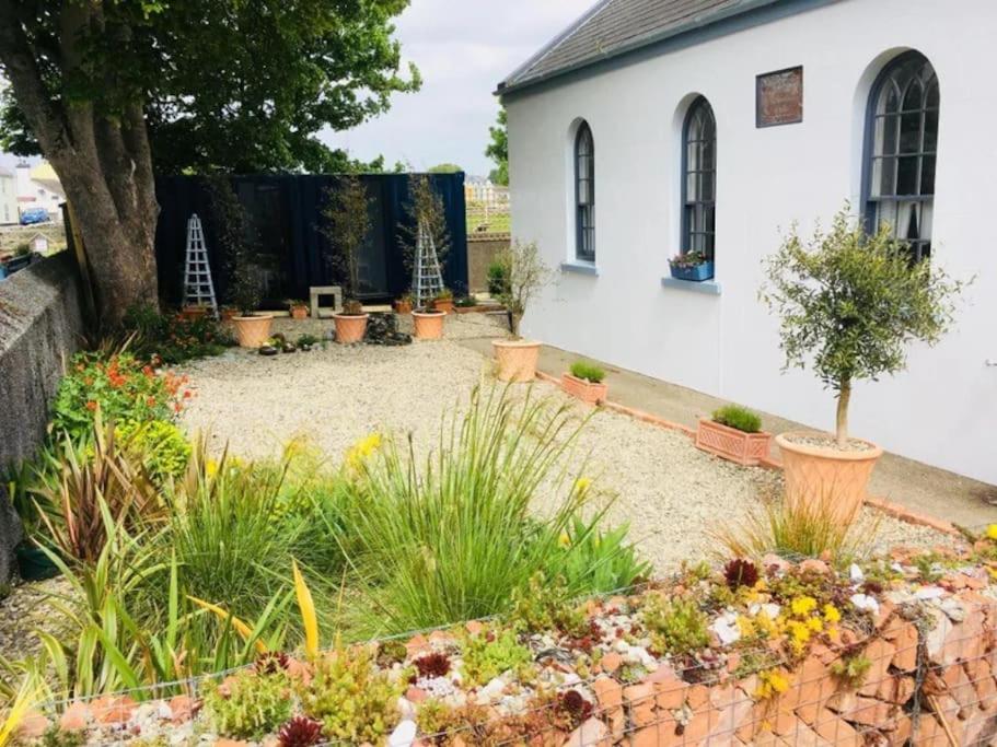 a garden in front of a white building at Preachers Rest in Killough