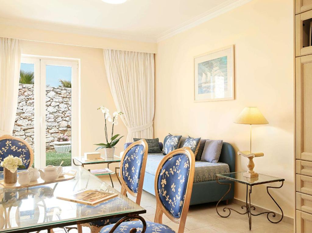 a living room with a couch and a table at Grecotel Marine Palace & Aqua Park in Panormos Rethymno