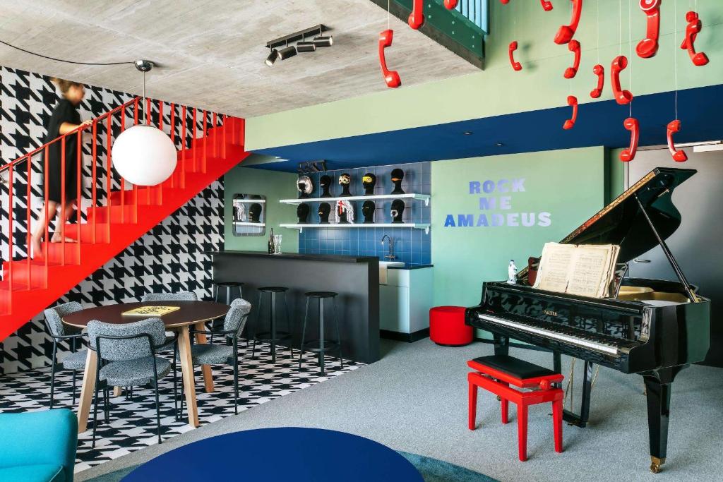 une chambre avec un piano, une table et un bar dans l'établissement The Social Hub Vienna, à Vienne