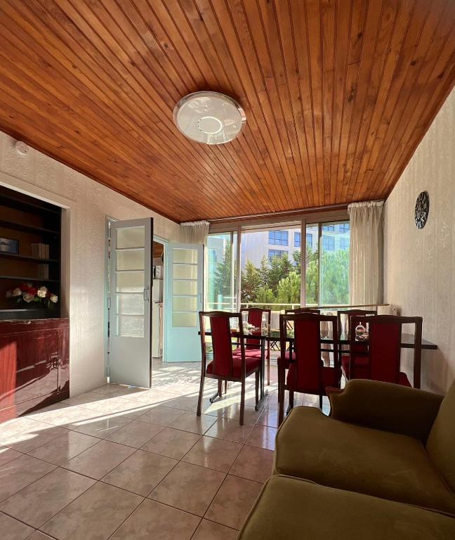 d'une salle à manger avec une table et des chaises et un plafond en bois. dans l'établissement Appartement familial à Paris, à Villejuif