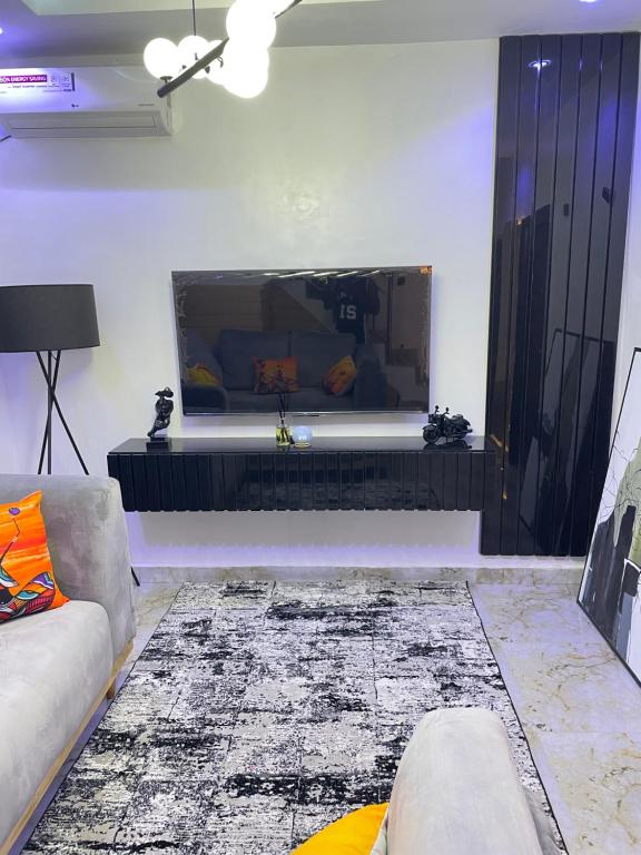 sala de estar con TV de pantalla plana grande en la pared en Modern 1bedroom Duplex, en Port Harcourt