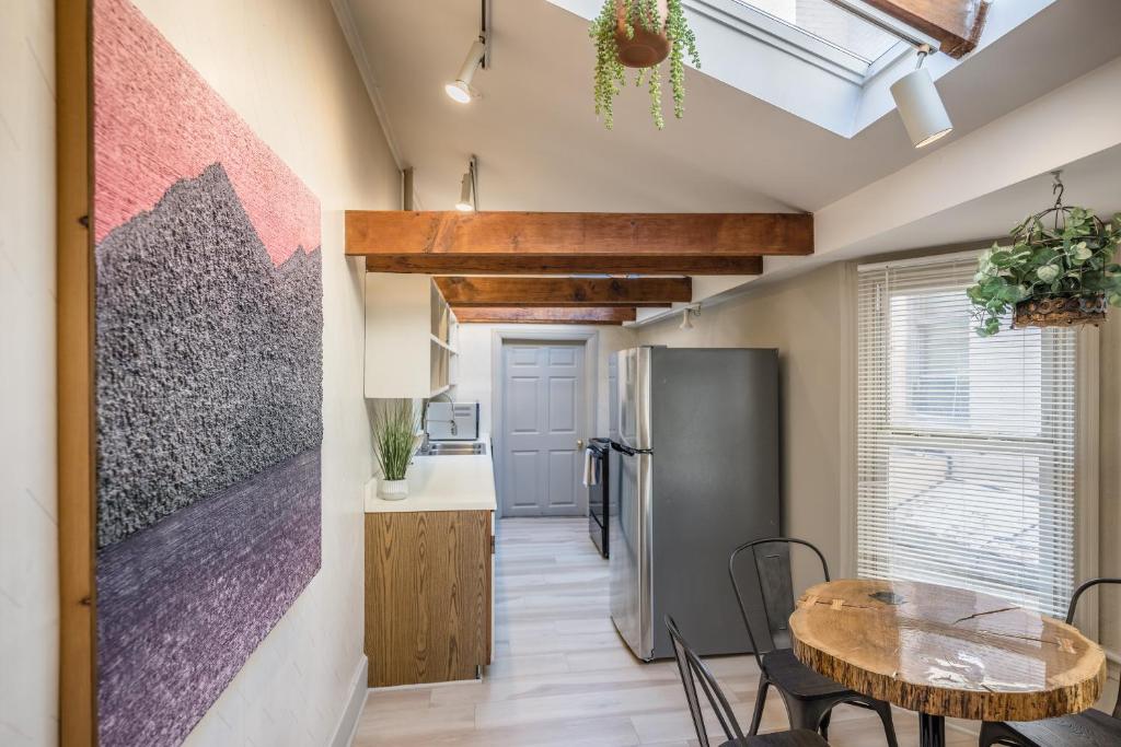 a kitchen and dining room with a table and a refrigerator at Row House Loft in Downtown Harrisburg near Hershey in Harrisburg