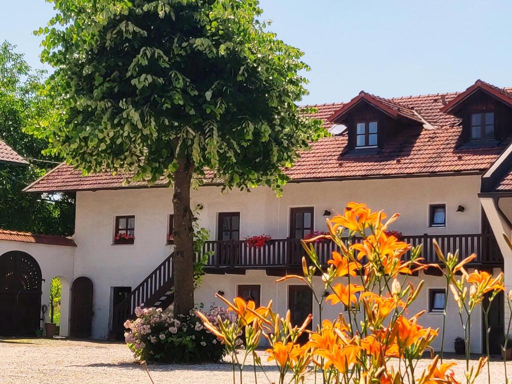 una casa con un árbol delante de ella en Pension Margaretenhof, en Bayerbach