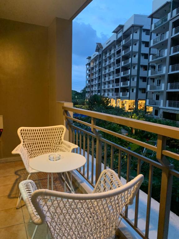 een tafel en stoelen op een balkon met uitzicht bij Alea Residences in Manilla