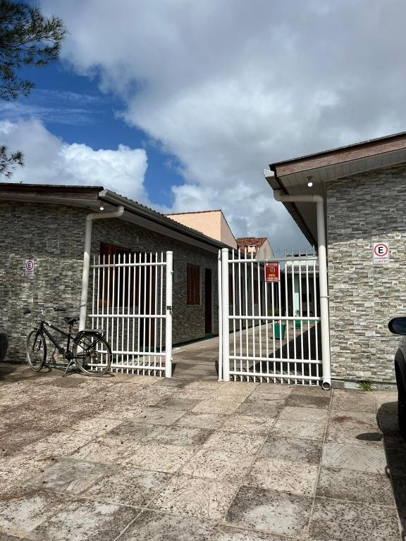 a white gate in front of a house at Apartamentos Pura Vida em Atlântida Sul in Xangri-lá