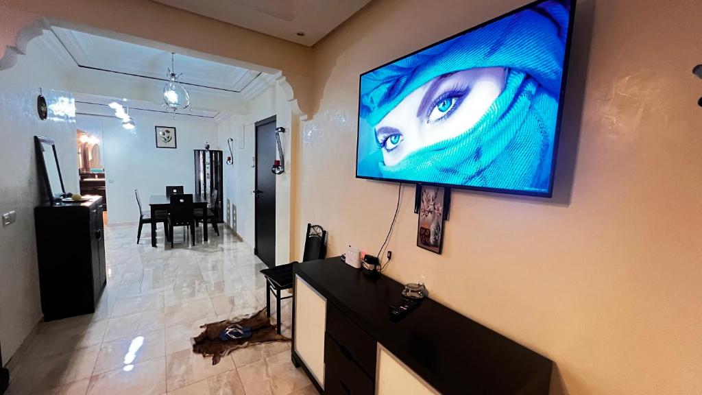 un salon avec une télévision murale à grand écran dans l'établissement Magnifique Appartement spacieux confort propre ,familial 2 chambres, salon salle à manger, 20mn a pied place jemaa el fina ,p3, à Marrakech