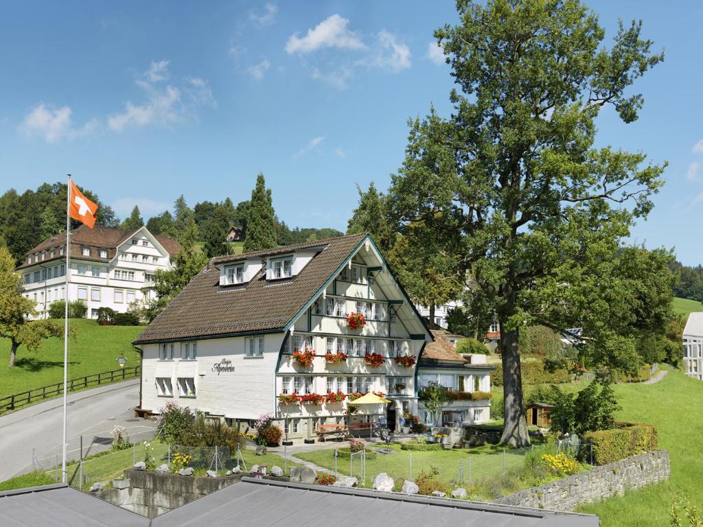 un gran edificio blanco con flores en la parte delantera en Alpenheim, en Teufen