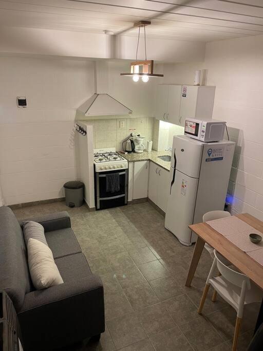 a small kitchen with a couch and a stove and refrigerator at Depto funcional en Comodoro! in Comodoro Rivadavia