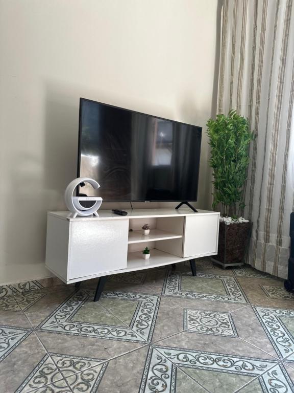 a living room with a tv and a white dresser at Casa alto Vidigal in Rio de Janeiro