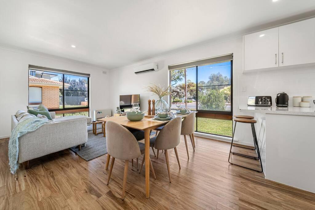 a kitchen and a dining room with a table and chairs at Harmony at Henley Beach - Coastal Style & Comfort in Grange