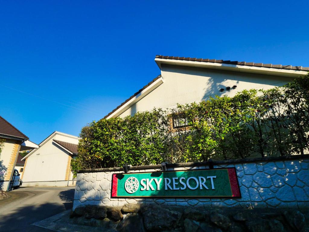 a sign for a synergy resort in front of a building at SKY Bay-Terace Omura in Omura