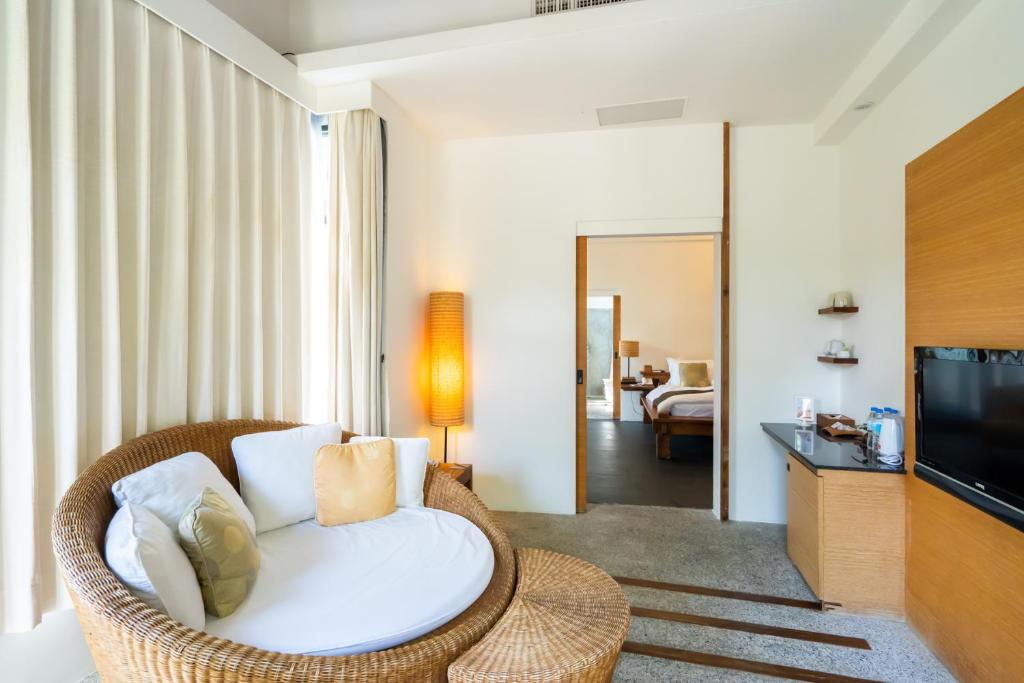 a living room with a wicker chair and a television at Mudanwan Villa in Mudan