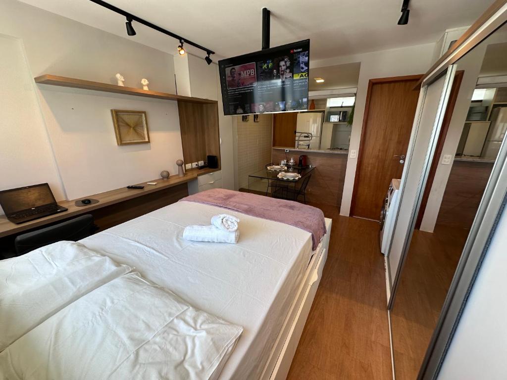 een slaapkamer met een bed en een televisie. bij Flat Novo e Moderno a 200m do Shopping , com Piscina wifii 500mbps in Recife