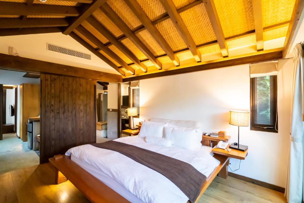 a bedroom with a large bed with a wooden ceiling at Mudanwan Villa in Mudan