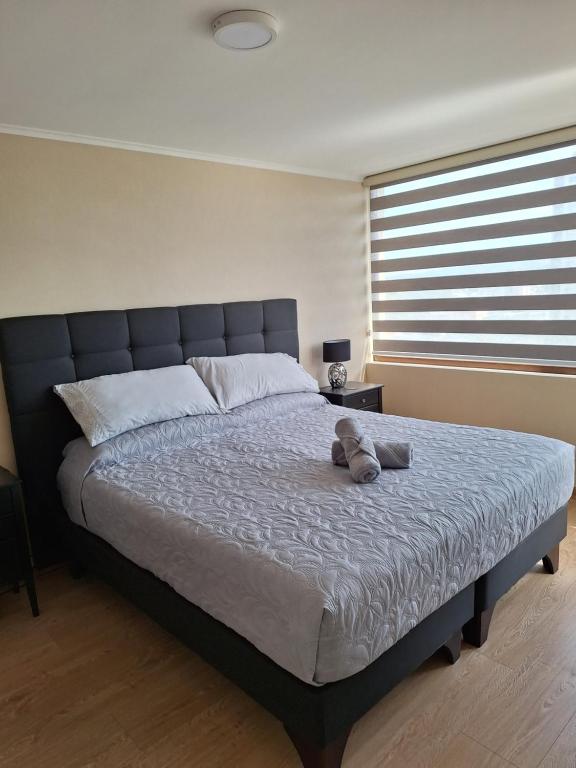 a bedroom with a large bed with a stuffed animal on it at Departamento Centro Lynch II in Temuco