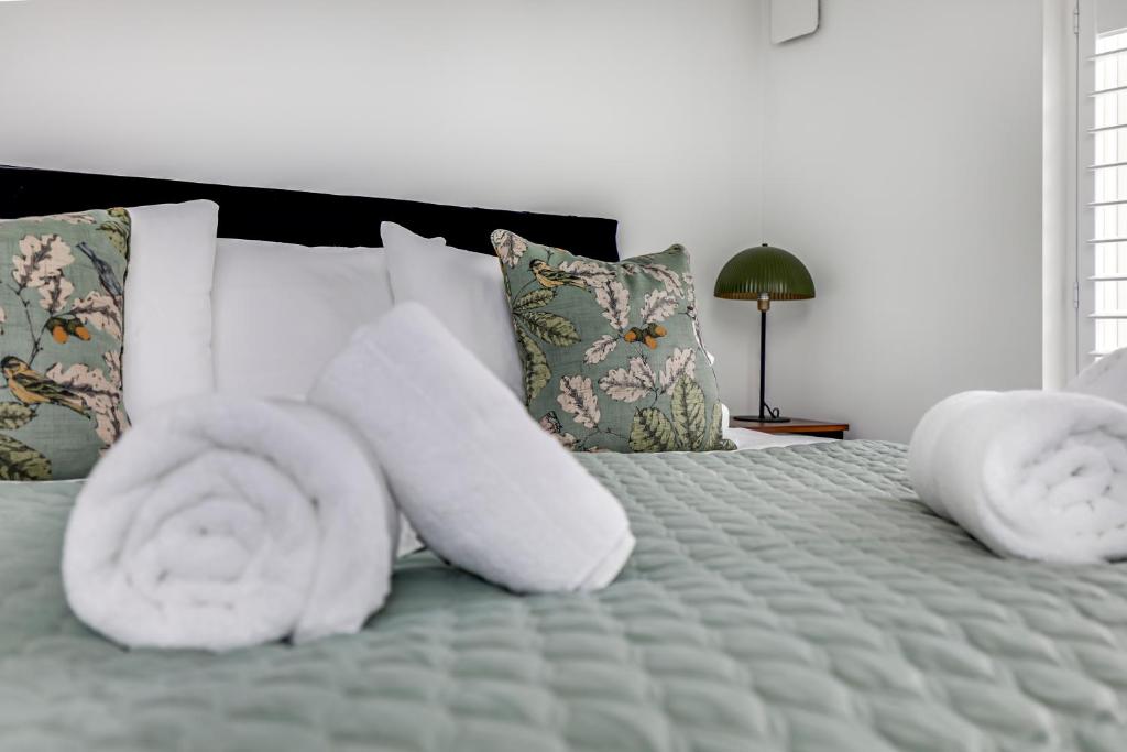 un letto con asciugamani bianchi sopra di Hemel Hampstead long-stay Residences a Hemel Hempstead