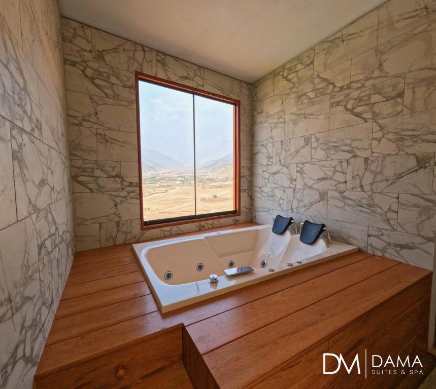 a bath tub in a room with a window at Dama Suites & Spa in Cieneguilla