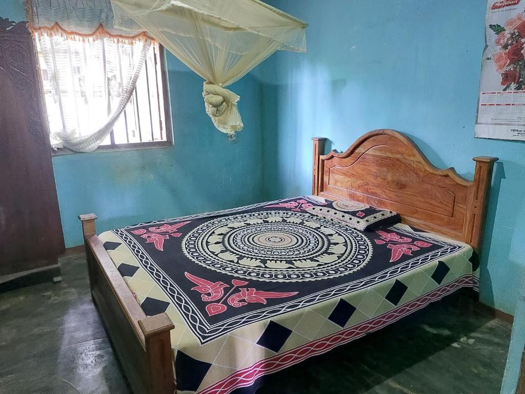 a bed in a blue room with a bedspread on it at Green Waves HomeStay in Nonagegama