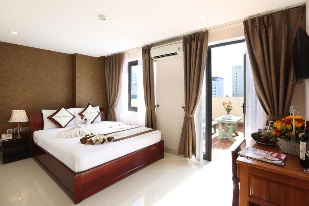 a bedroom with a large bed and a large window at Kingdom Danang Hotel in Da Nang