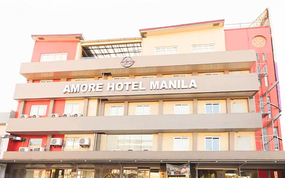 a hotel building with a sign that reads anytime hotel manila at AMORE HOTEL MANILA in Manila