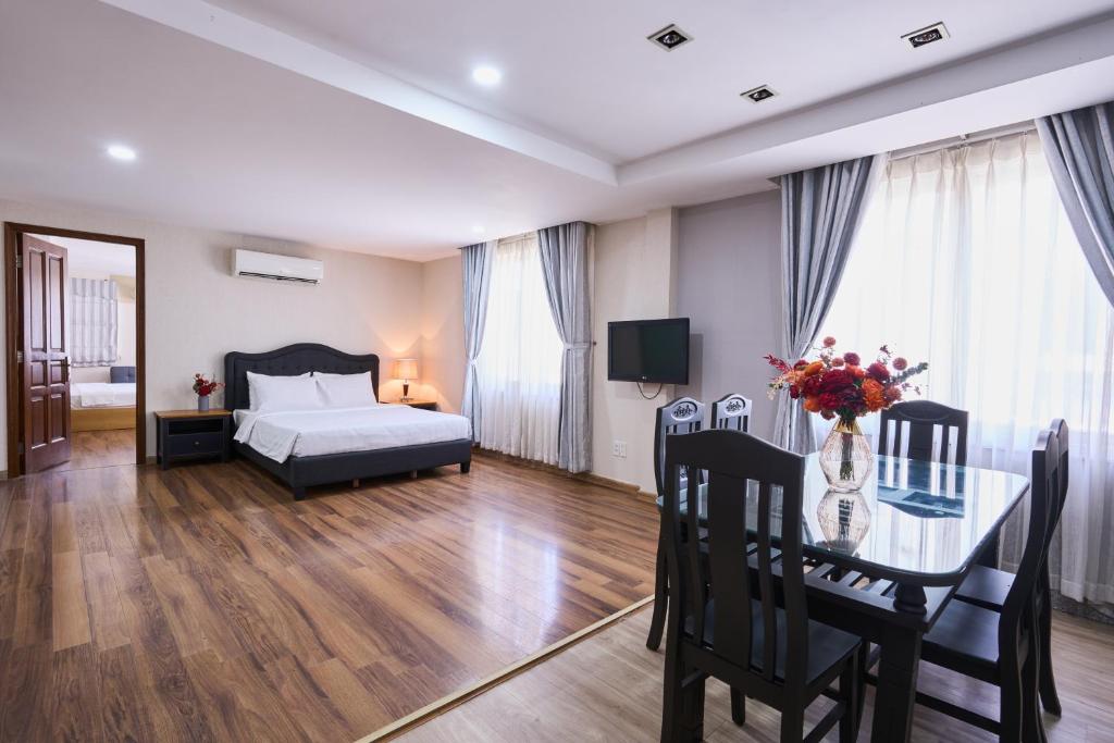 a bedroom with a bed and a table and a bed and a room at La Palma Boutique Hotel in Ho Chi Minh City