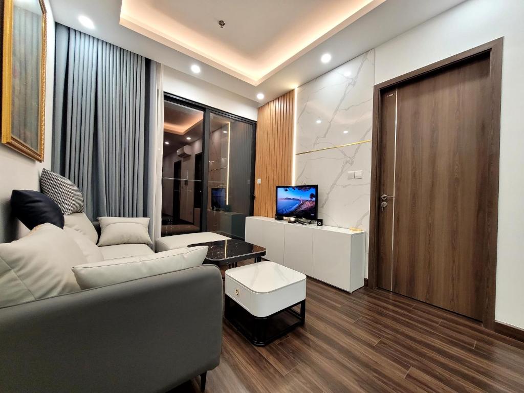 sala de estar con sofá y TV en Na Mit HomeStay, en Hai Phong
