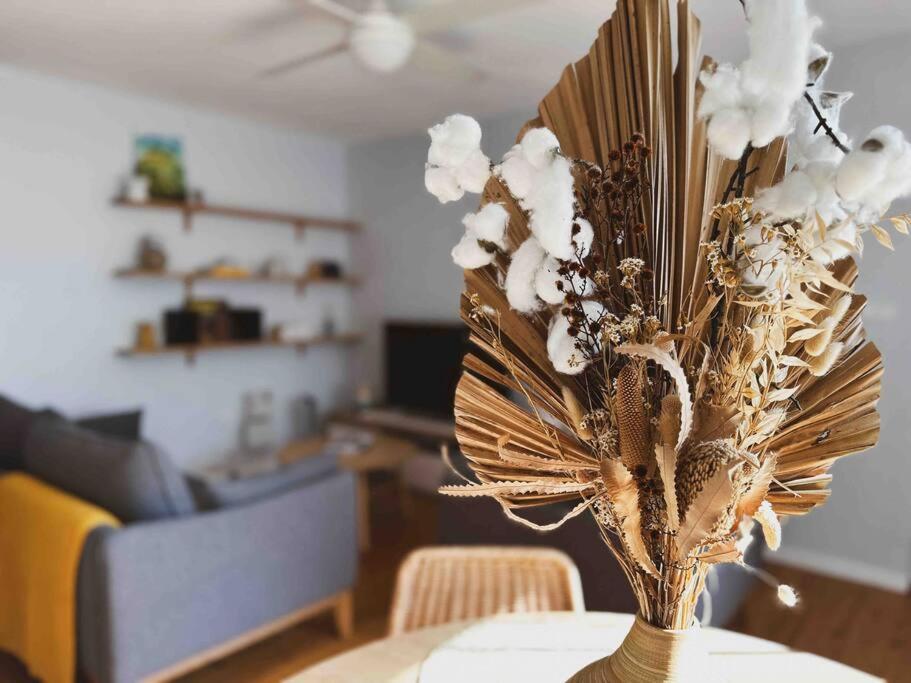 a vase with flowers on a table in a living room at Harbourside Bliss: 2-Bedroom Coastal Apartment in Wollongong