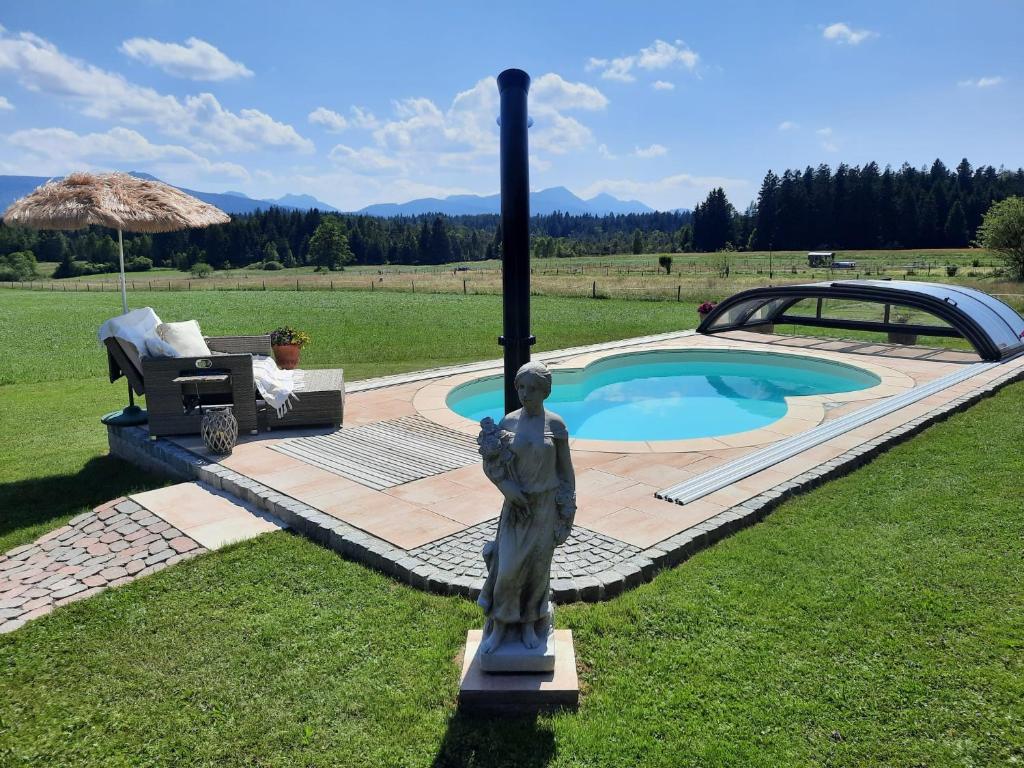 eine Statue einer Frau neben einem Schwimmbad in der Unterkunft Ferienwohnung am Wirtshof in Siegsdorf