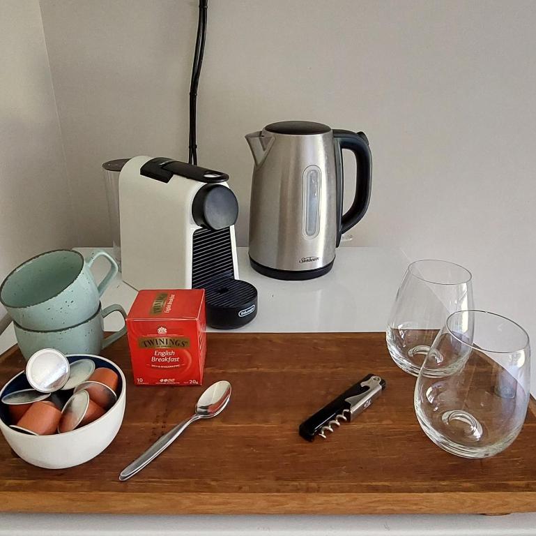 a counter with a coffee maker and glasses on it at Private guest room - no kitchen in Wanaka