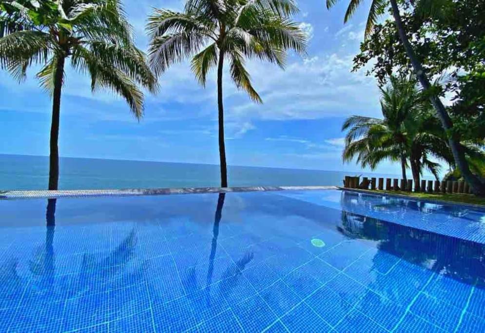 una piscina con palmeras y el océano en Casa En El Risco, 