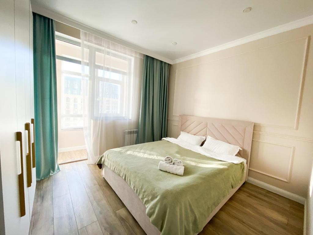 1 dormitorio con cama y ventana grande en Highvill Ishim 412 en Astaná