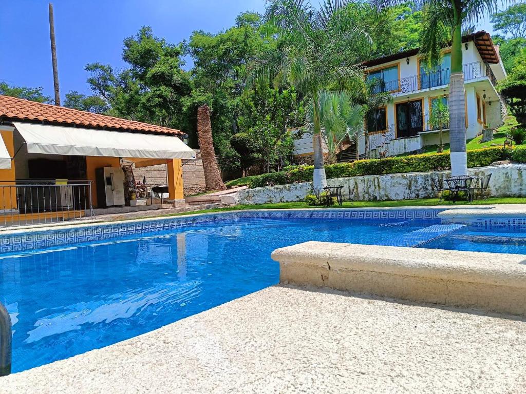 a swimming pool in front of a house at Cabaña de lujo con Terraza para eventos in San José del Puente
