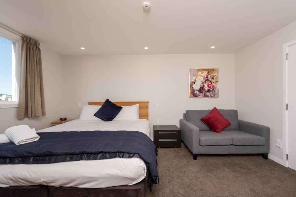 a hotel room with a bed and a chair at Capital View Motor Inn - Free Parking in Wellington