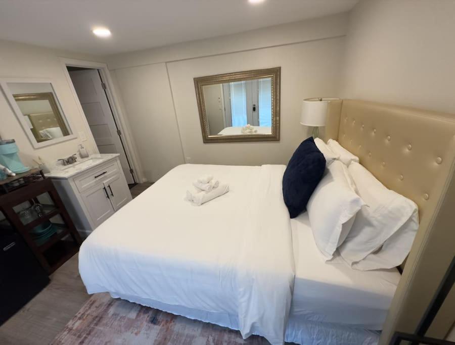 1 dormitorio con cama blanca y espejo en Guest House next to Little Italy, en San Diego