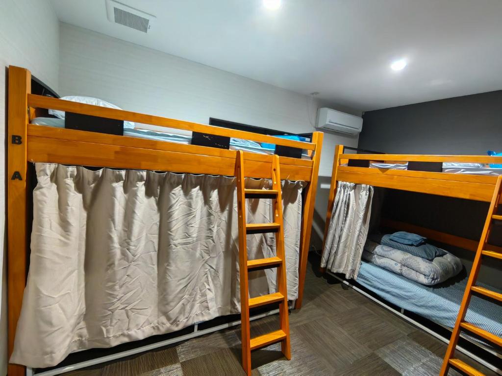 two bunk beds in a room with a ladder at Mini Inn Kyoto 京都 - 外国人向け - 日本人予約不可 in Kyoto