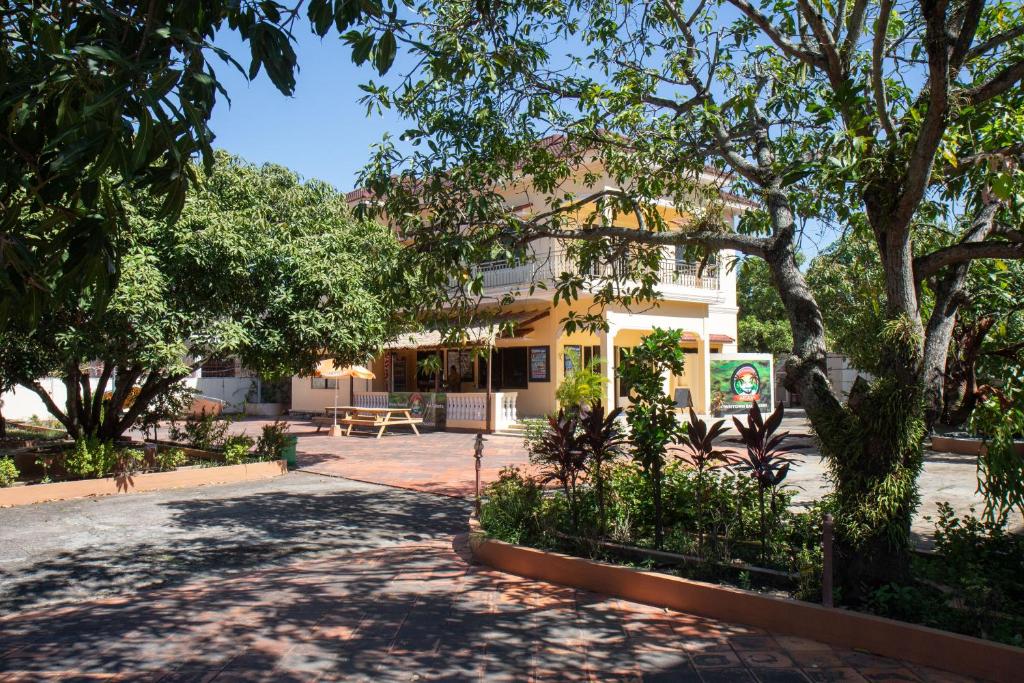 ein Gebäude mit Bäumen davor in der Unterkunft Arcadia Downtown Backpackers in Kampot