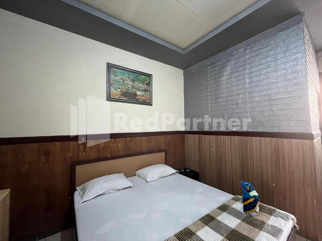 Postel nebo postele na pokoji v ubytování Hotel Dewi near GOR Merdeka Jombang Mitra RedDoorz