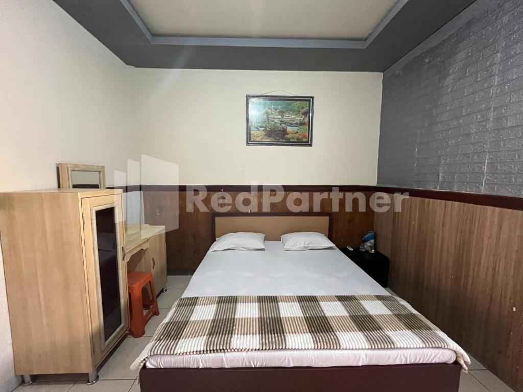 Postel nebo postele na pokoji v ubytování Hotel Dewi near GOR Merdeka Jombang Mitra RedDoorz