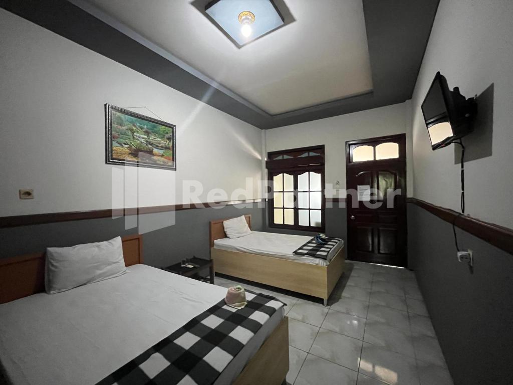 Postel nebo postele na pokoji v ubytování Hotel Dewi near GOR Merdeka Jombang Mitra RedDoorz