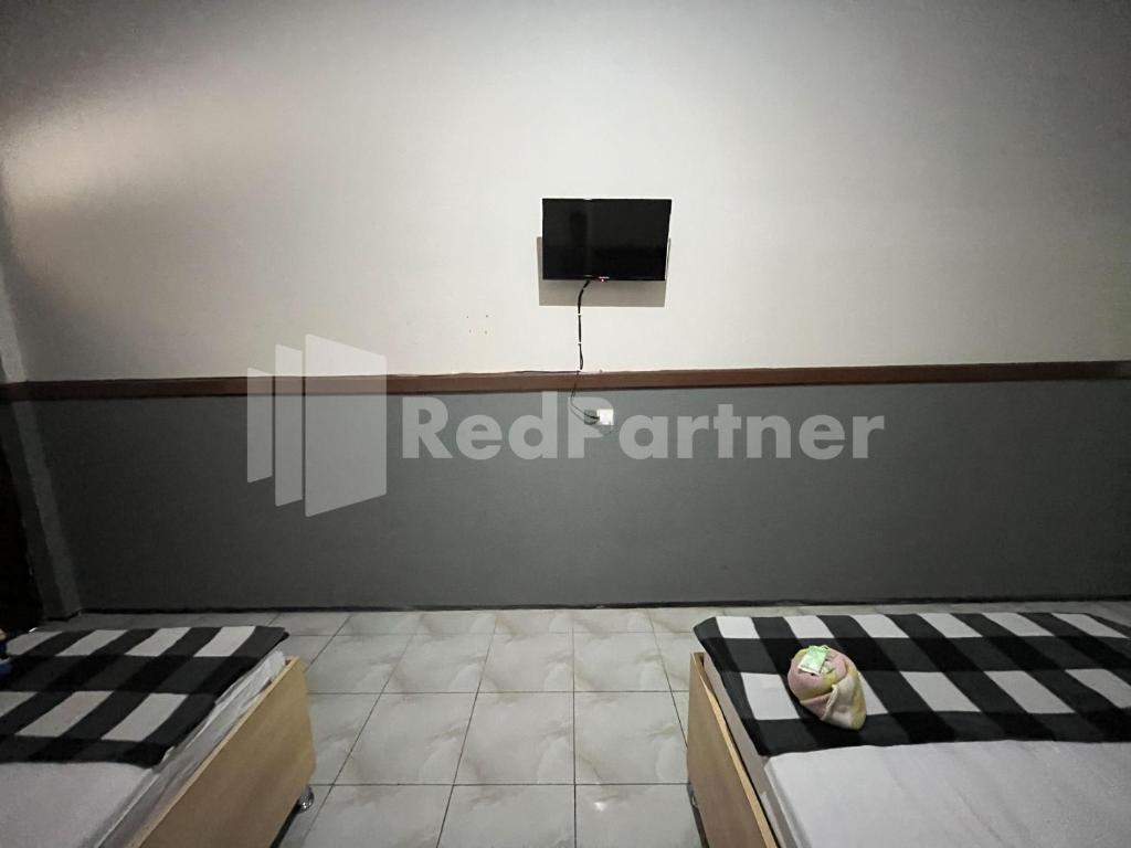 Postel nebo postele na pokoji v ubytování Hotel Dewi near GOR Merdeka Jombang Mitra RedDoorz