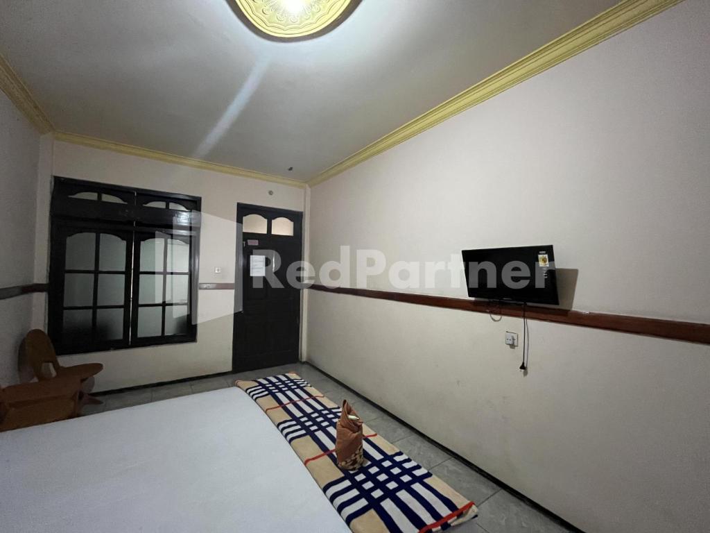 Postel nebo postele na pokoji v ubytování Hotel Dewi near GOR Merdeka Jombang Mitra RedDoorz