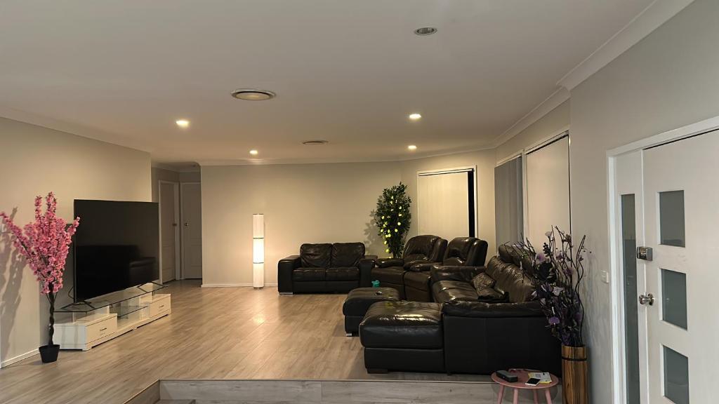 ein Wohnzimmer mit Sofas und einem Flachbild-TV in der Unterkunft Luxurious and spacious home in taree in Taree