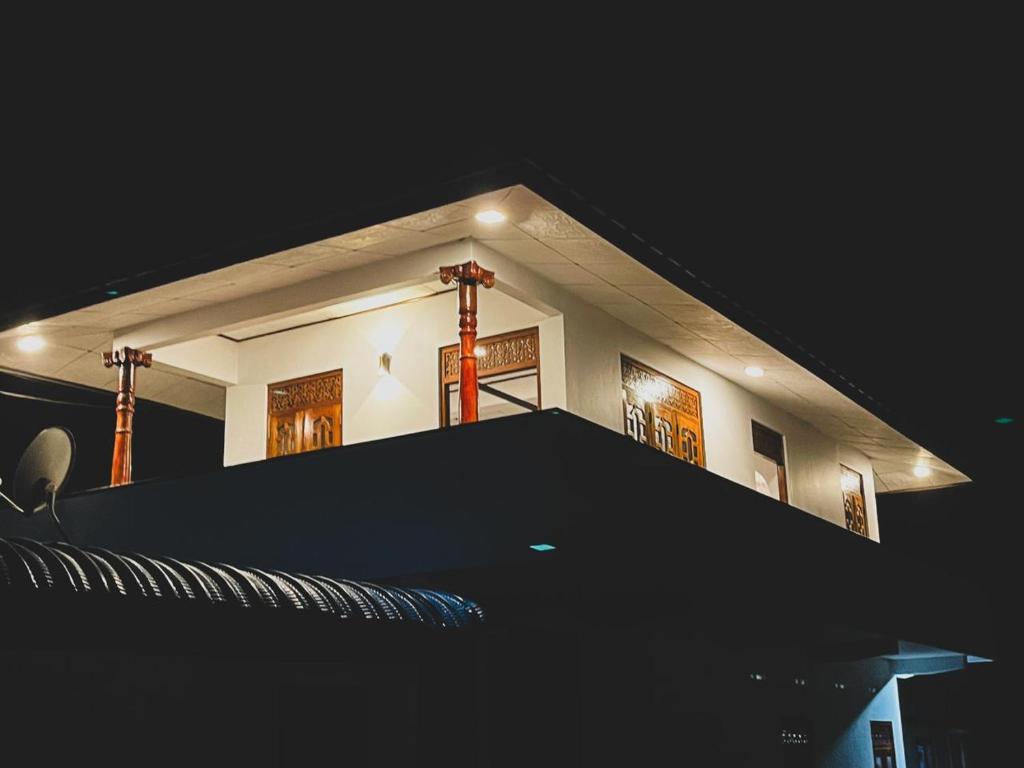 a building with a black roof at night at Shanika Guest & Villa in Mirissa