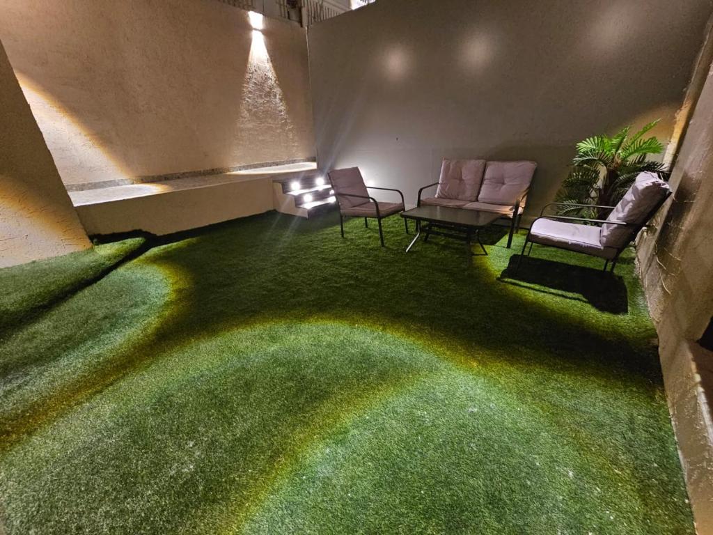 a room with two chairs and a green carpet at Sky2030Group in Dammam