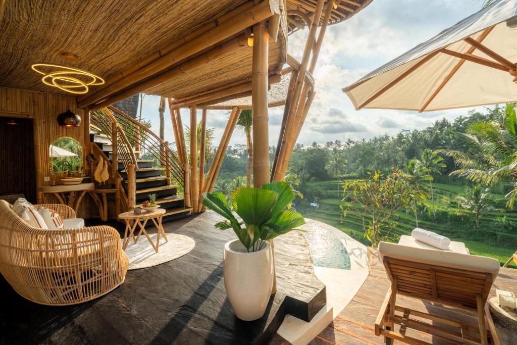 een woonkamer met uitzicht op de jungle bij Bambootel Sawah View in Ubud