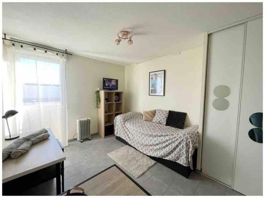 une chambre avec un lit et un bureau dans l'établissement Studio Castelnau le lez proche Montpellier odysseum et tram, à Castelnau-le-Lez