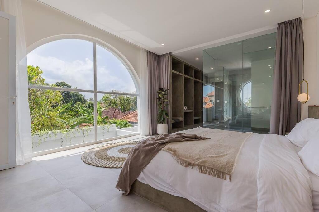 a bedroom with a large bed and a large window at VILLA EUDORA BALI in Tumbak Bayuh