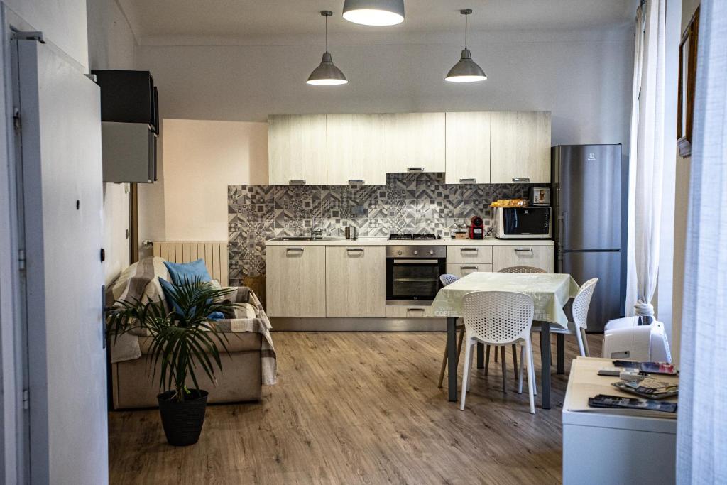 a kitchen with white cabinets and a table and chairs at Civico 10 in Sanremo