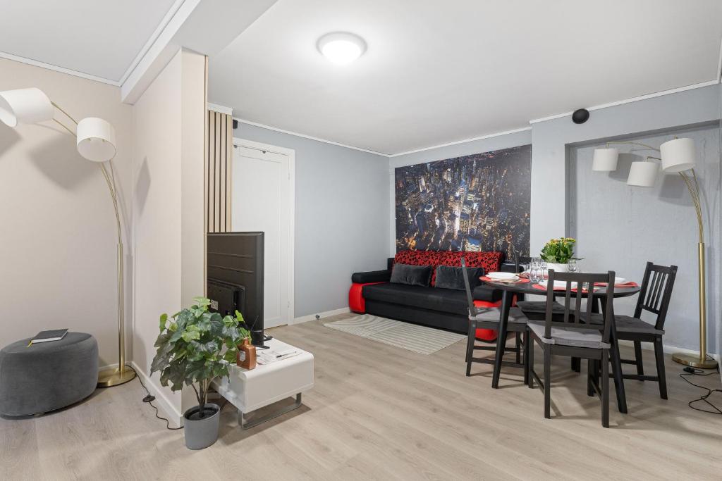 a living room with a black couch and a table at Apartments Bergen free parking in Bergen