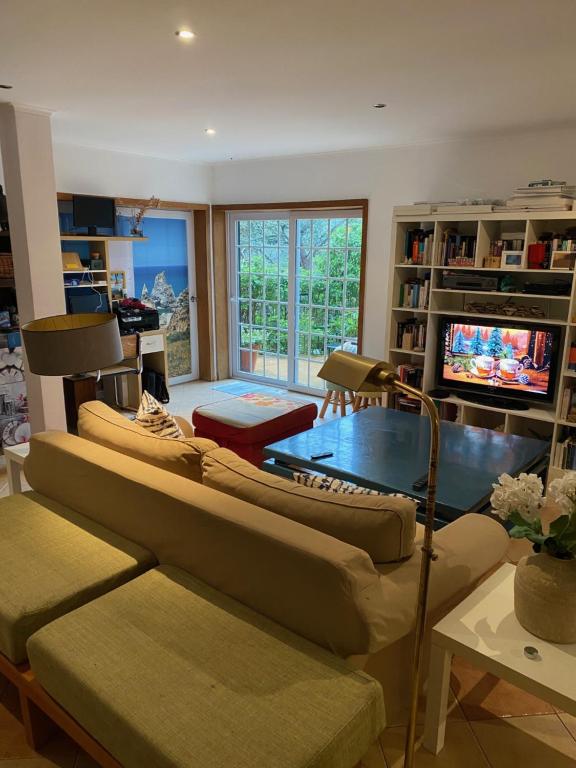 a living room with two couches and a tv at Amazigh Guincho Hostel & Suítes in Cascais